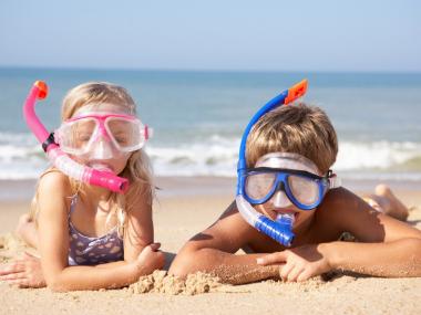 Børn på strand med svømmebriller